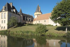 a large building next to a body of water at Chambre chez l habitant Audrey in Saligny-sur-Roudon