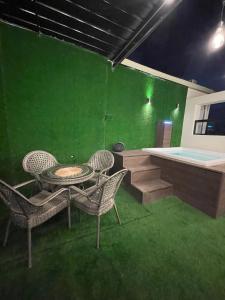 Zimmer mit grüner Wand, Tisch und Stühlen in der Unterkunft Studio 27 in Santo Domingo