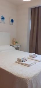 two towels are sitting on top of a bed at los pisitos de El Barraco 2 in El Barraco +13 photos