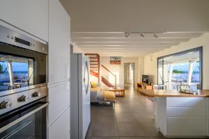 een keuken en een woonkamer met uitzicht op de oceaan bij Villa Paruline in Grand-Bourg