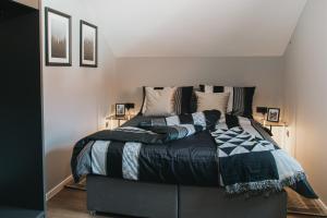 a bedroom with a bed with a black and white comforter at The Loft / Hill View Modern Apartment in Samobor