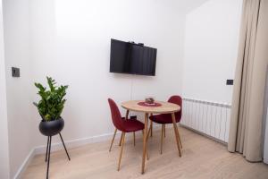 a dining room with a table and chairs and a tv at Belgrade Waterfront Cozy Symphony 1 in Sajmište