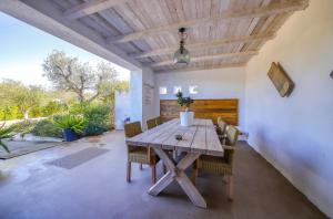 ein Esszimmer mit einem Holztisch und Stühlen in der Unterkunft Tenuta Rurale Luxury&Nature in Gravina in Puglia