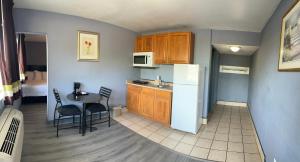 a small kitchen with a table and a refrigerator at Americas Best Value Inn and Suites Groves in Groves