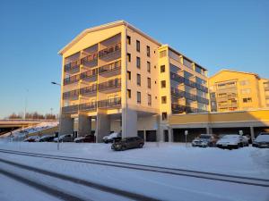 een groot gebouw met auto's geparkeerd op een parkeerplaats bij Apartment with Sauna in the heart of Rovaniemi in Rovaniemi