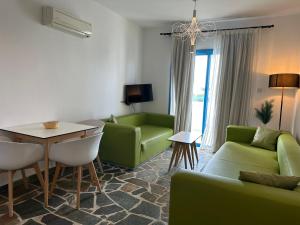 - un salon avec un canapé vert et une table dans l'établissement Tasmaria Aparthotel, à Paphos