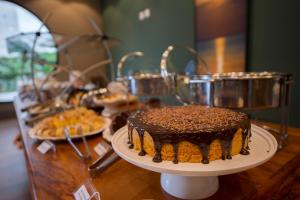 een tafel met een chocoladetaart op een bord bij KEEP SUÍTES HOTEL in Taubaté