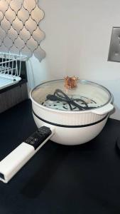 a remote control sitting next to a bowl with a glass lid at Kazoku 2BR Family Condo at Shaw in Manila