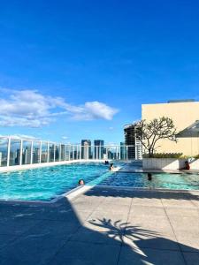 a large swimming pool on top of a building at Kazoku 2BR Family Condo at Shaw in Manila