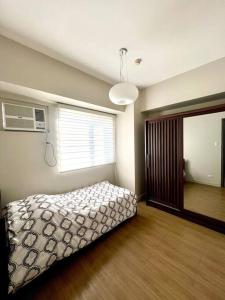 a bedroom with a bed and a window at Kazoku 2BR Family Condo at Shaw in Manila
