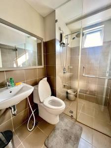 a bathroom with a toilet and a sink and a shower at Kazoku 2BR Family Condo at Shaw in Manila