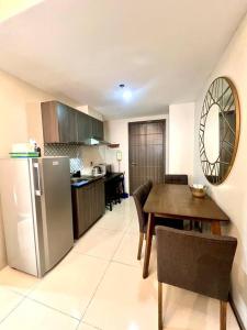 uma cozinha com uma mesa, um frigorífico e uma sala de jantar em Kazoku 2BR Family Condo at Shaw em Manila