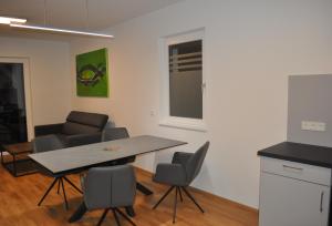 a kitchen and dining room with a table and chairs at Sonnige Neubauwohnung - Gratwein in Kugelberg