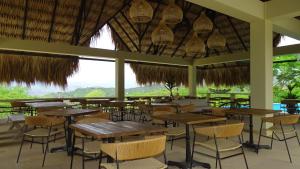 a restaurant with tables and chairs and a large window at Selva Serena in Anapoima