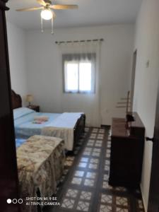1 dormitorio con 2 camas y ventilador de techo en Cortijo Ferre, a los pies del castillo la Atalaya de Nijar en Níjar