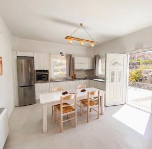 a kitchen with a white table and chairs at Villas Scirocco in Fira