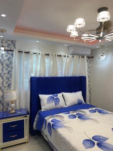 1 dormitorio con cama azul y edredón azul y blanco en Coconut paradise Residences, 