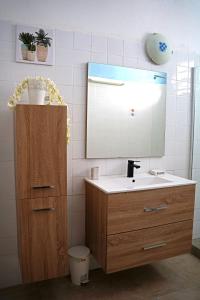 W łazience znajduje się umywalka i lustro. w obiekcie Loca Vacances w mieście Sainte-Anne