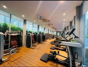 une salle de sport avec une rangée de tapis de course et de machines dans l'établissement near klcc vortex suites by PLUS POIN, à Kuala Lumpur