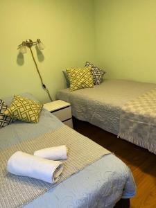 Zimmer mit 2 Betten und einer Lampe in der Unterkunft Patagonia Tower in Puerto Natales
