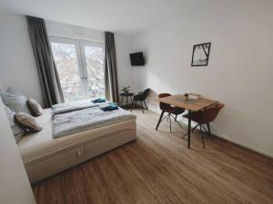 um quarto com uma cama e uma mesa com cadeiras em CASA BEACH-Zentral-Outlet-Aufzug-Parkplatz-Unique em Metzingen