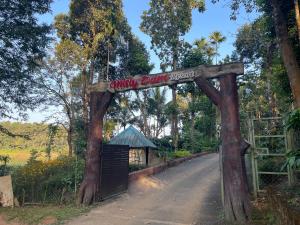 Zugang zu einem Affenpark mit einem Schild auf einer Straße in der Unterkunft Misty Dam Wayanad Premium Resort With Banasura Dam View in Padinjarathara