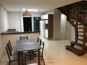 a kitchen and dining room with a table and chairs at Sobrados com suíte e sacada vista ao mar in Capão da Canoa