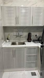 a kitchen with white cabinets and a sink at Marbella Resort in Al Ain
