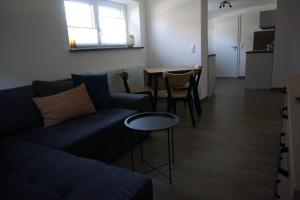 una sala de estar con un sofá y una mesa en FeWo herein SPAZIERT, en Schmiedefeld am Rennsteig