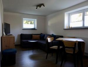 una sala de estar con un sofá y una mesa en FeWo herein SPAZIERT, en Schmiedefeld am Rennsteig