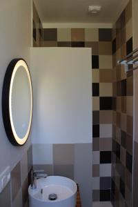 a bathroom with a sink and a mirror at La Riveraine et les bicyclettes in Saint-Sauveur-de-Montagut