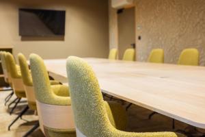 Serra Boutique Hôtel في آجا: قاعة اجتماعات مع طاولة طويلة وكراسي صفراء