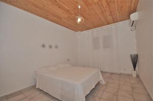 a white room with a bed and a wooden ceiling at Loca Vacances in Sainte-Anne