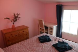 a bedroom with a bed and a desk and a window at Maison au calme 2 chambres centre de Caen in Caen