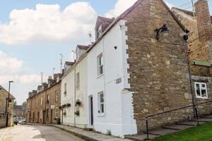 a row of brick buildings on a street at Stunning 2BD in the Heart of Malmesbury! in Malmesbury