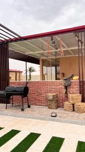 un patio con parrilla y pared de ladrillo en Marbella Resort, en Al Ain
