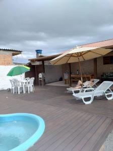 una persona tendida en sillas en una terraza junto a una piscina en Moradas dos Sonho, en Palhoça