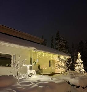 Una casa coperta di luci natalizie nella neve di Arctic Circle Home for Winter Holiday a Rovaniemi