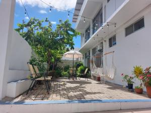 einen Innenhof eines Gebäudes mit Stühlen und einem Sonnenschirm in der Unterkunft Hotel Islas Galapagos in Puerto Baquerizo Moreno