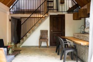 a dining room with a table and chairs and a staircase at VODA Hotel & Spa in Galle