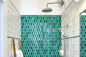 ein Badezimmer mit grünen gefliesten Wänden und einer Dusche in der Unterkunft Fully equipped apartment Budapest, Hungary in Budapest