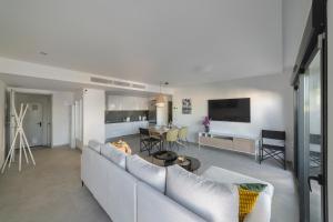 sala de estar con sofá blanco y cocina en Apartment in Gran Alacant with Sea View, AC, pool en Gran Alacant