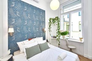 sypialnia z niebieską ścianą z łóżkiem i oknem w obiekcie Fully equipped apartment Budapest, Hungary w Budapeszcie