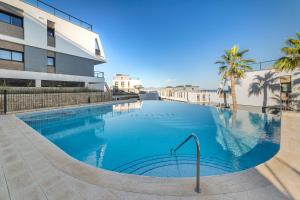 una gran piscina frente a un edificio en Apartment in Gran Alacant with Sea View, AC, pool en Gran Alacant