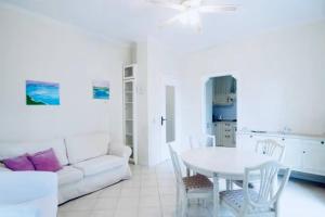 ein weißes Wohnzimmer mit einem weißen Tisch und einem weißen Sofa in der Unterkunft [Garda Lake]-Raffinato appartamento in Toscolano-Maderno