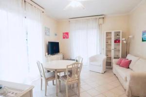 ein Wohnzimmer mit einem Tisch und einem Sofa in der Unterkunft [Garda Lake]-Raffinato appartamento in Toscolano-Maderno
