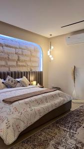 a bedroom with a large bed and a brick wall at Marbella Resort in Al Ain