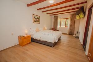 卡哈马卡HOTEL & SPA LAGUNA SECA的卧室配有一张大床和木地板