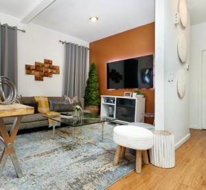 un soggiorno con divano e TV di A Dedicated Space To Unwind a Brooklyn