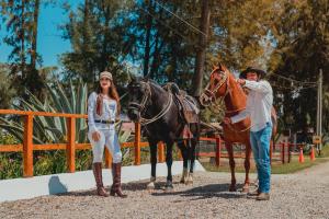 een man en een vrouw die naast een paard staan bij HOTEL & SPA LAGUNA SECA in Los Baños del Inca